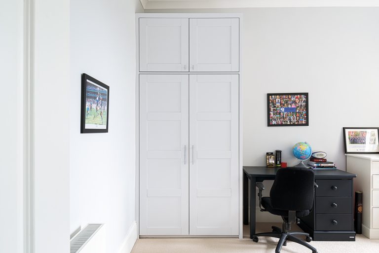 White wardrobe next to a desk