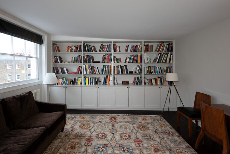 Built-in cupboard with 8 doors and shelving units to store lots of books.