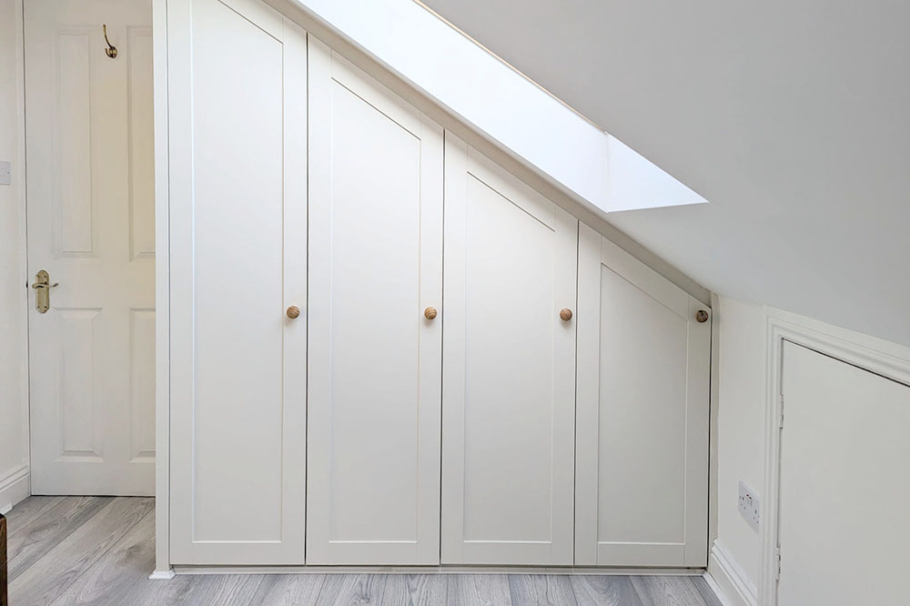 Built-in loft wardrobe with 4 doors in attic bedroom