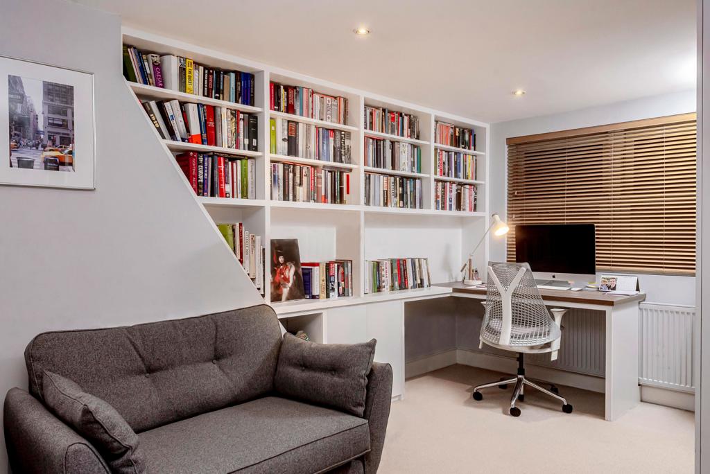 Built-in home office unit with shelving and desk in corner of room.