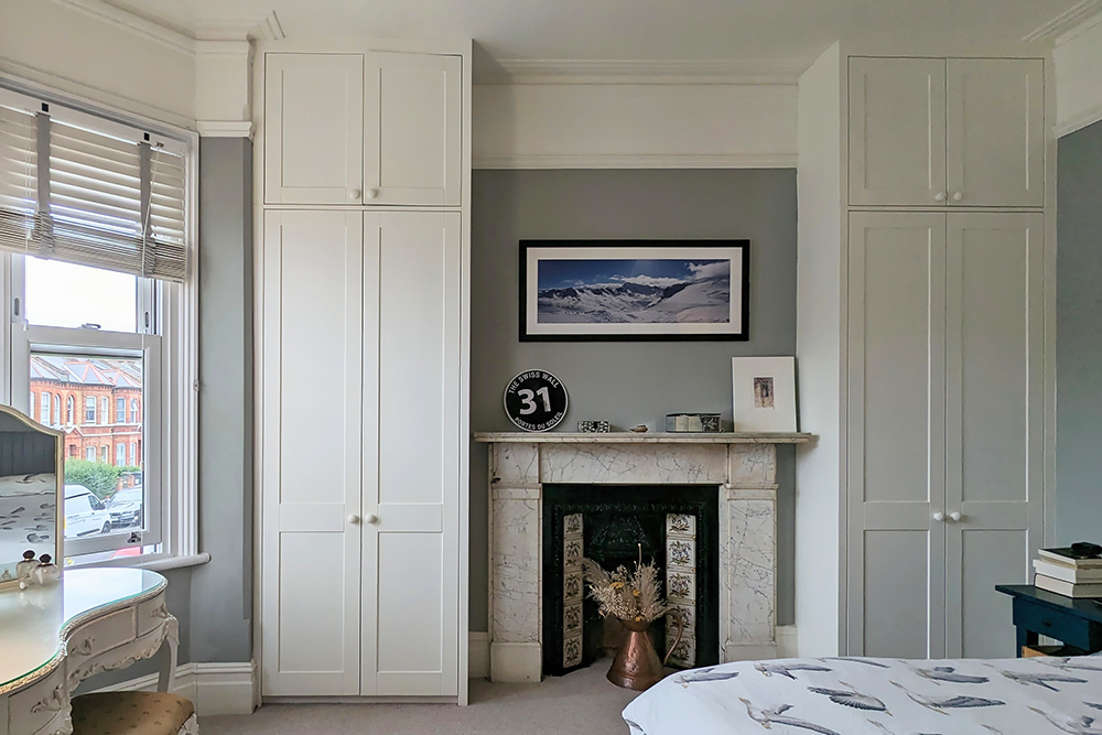 Fitted alcove wardrobes next to chimney, floor to ceiling.