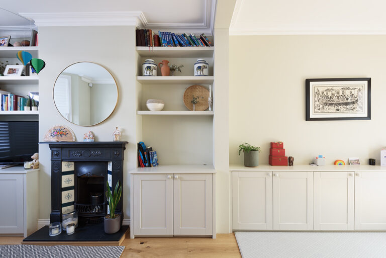 Built-in alcove cupboards and shelving in living room, next to fire place