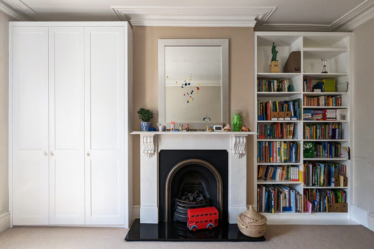 Built-in wardrobe and bookshelf in kids bedroom in alcove units.