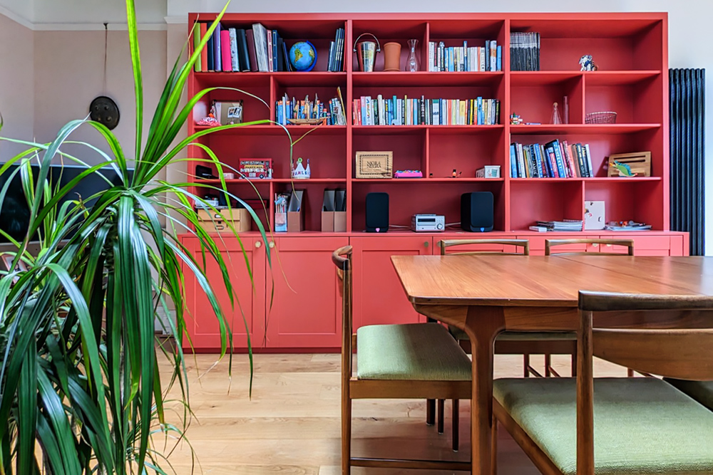 Large built-in cupboard with 6 doors at the bottom and shelving unit to store books in the living space