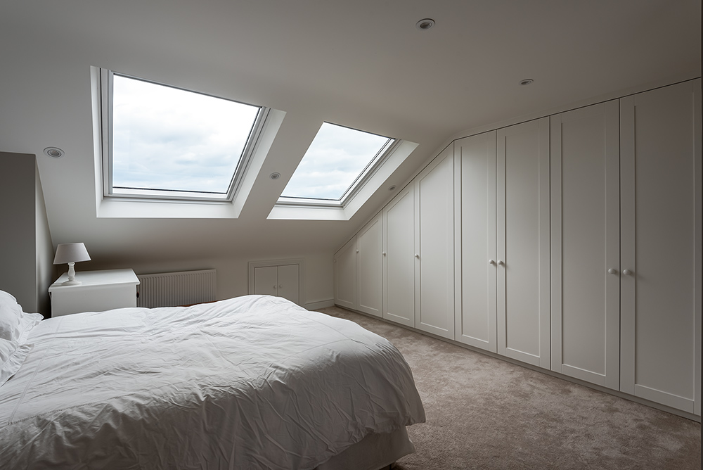 Large built-in loft wardrobe with 8 doors in spare room