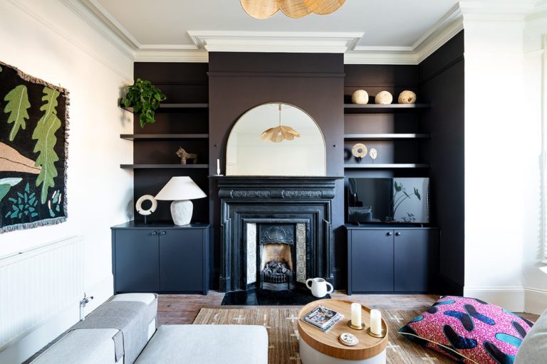 Beautiful blue built-in alcove cupboards with alcove floating shelves next to fireplace.