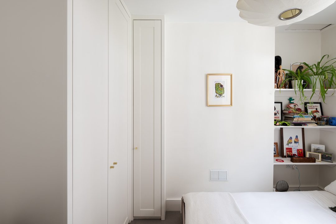 Fitted white corner wardrobe in bedroom