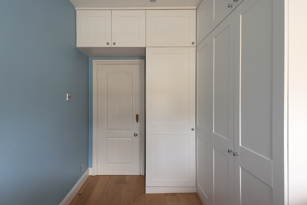 Corner bespoke wardrobe going above the door