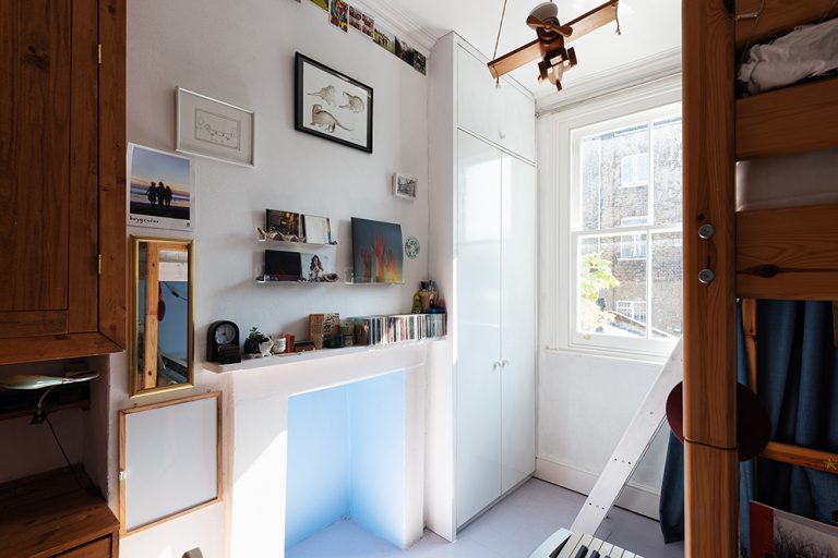 Fitted alcove wardrobe in corner of kid's bedroom.