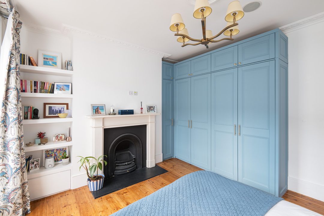 Blue built In walk in wardrobe in bedroom.