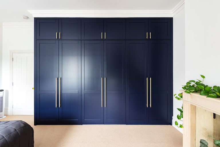 Blue bespoke wardrobe with 6 doors. Designed and installed by Bespoke Carpentry London.