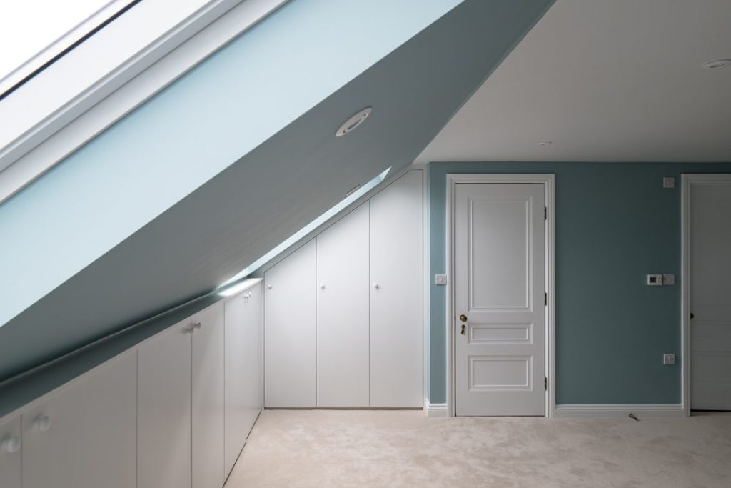 Fitted white loft wardrobe in bedroom