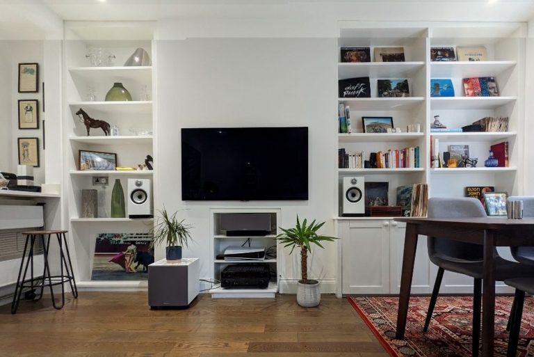 Multiple shelving units in alcove spaces near kitchen