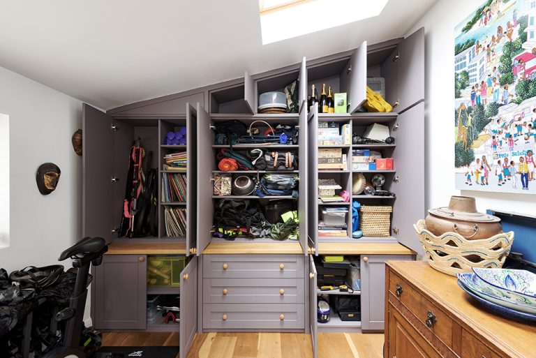 Inside view of a bespoke wardrobe with all the doors open. Built by carpenters at Bespoke Carpentry London