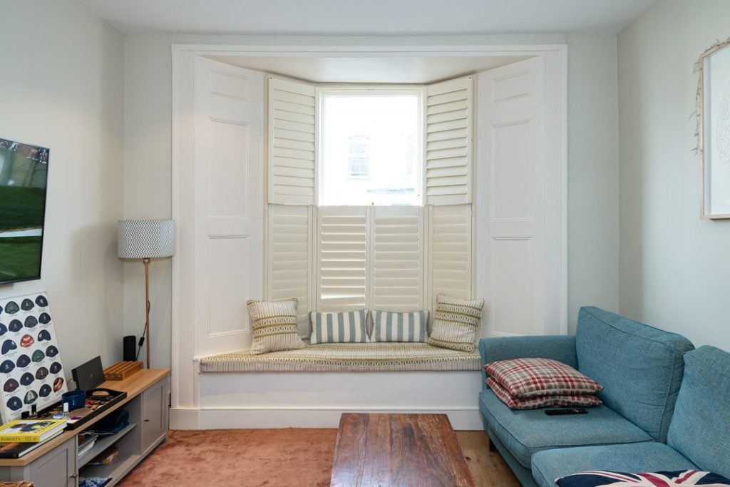 Built In bay window seat in living room with cushions on top.