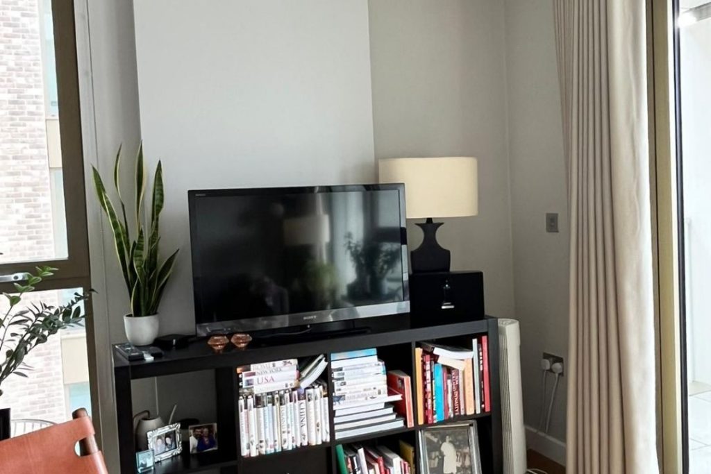 TV unit on a stand next to wall