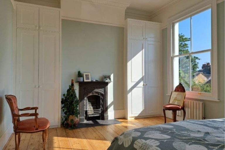 Bespoke alcove wardrobe in bedroom next to fireplace