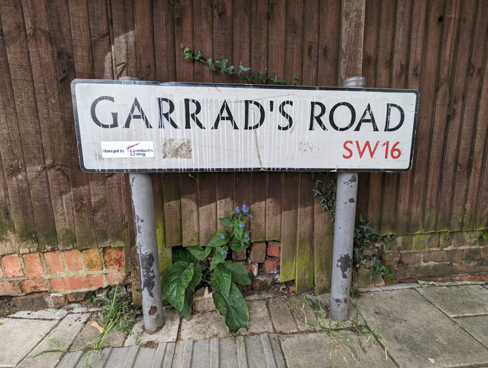 A white sign near a fence in Streatham