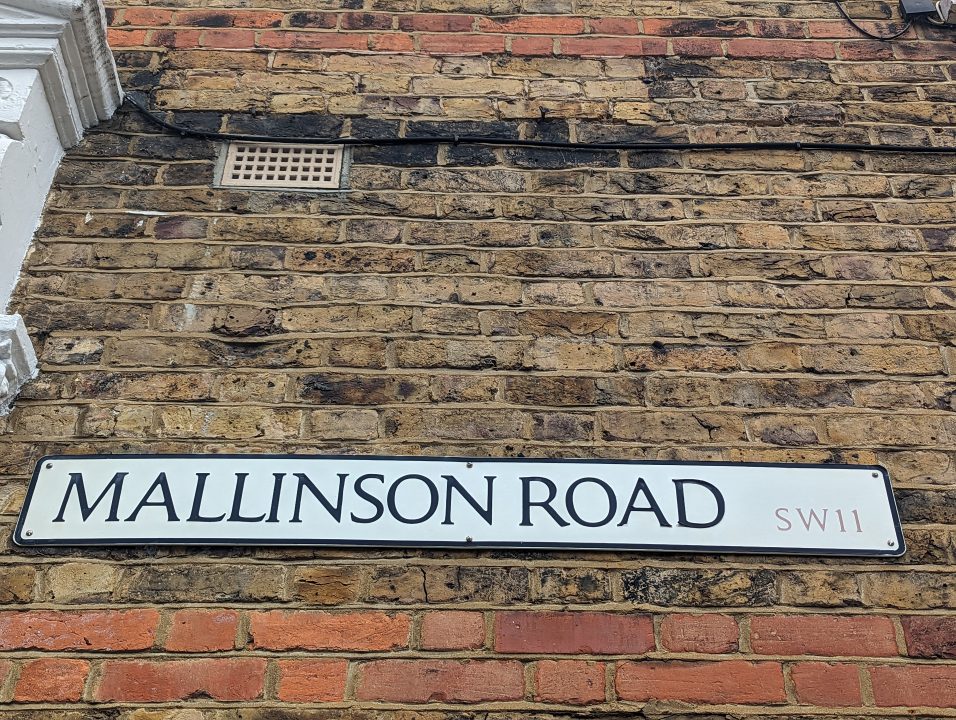 A brick wall with a road sign in Clapham area