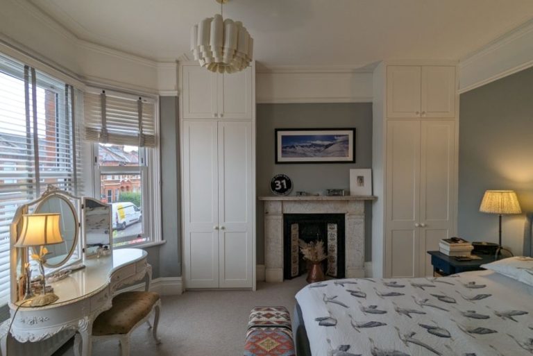 two fitted alcove wardrobes next to chimney