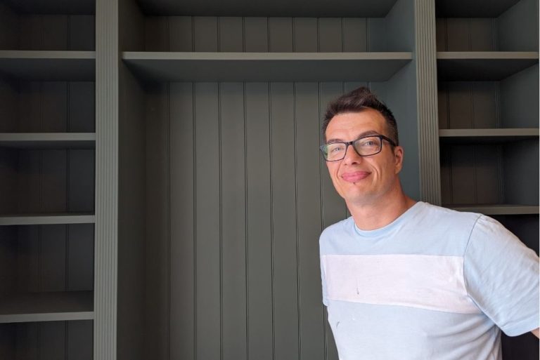 A painter next to painted green bookcase