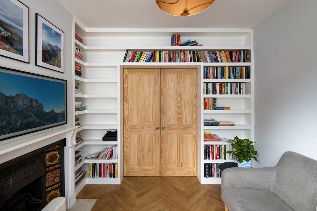 Built in white bookshelf over the door