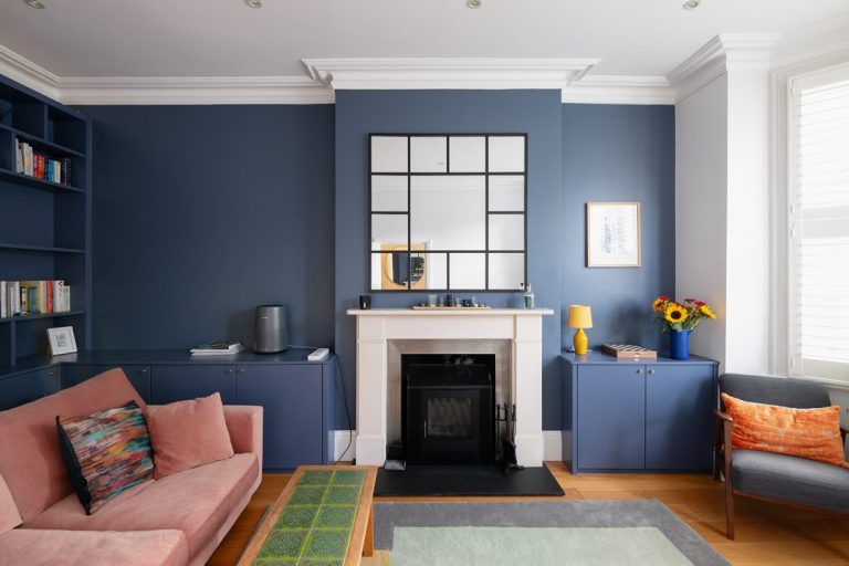 Blue fitted alcove cabinets next to chimney