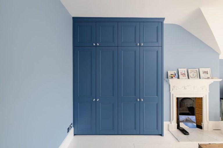 Built in blue 4 door wardrobe in alcove space