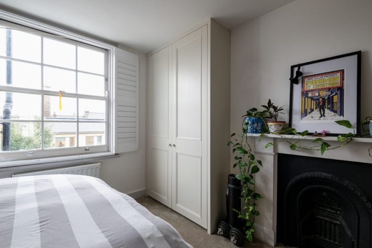 White built in alcove wardrobe next to chimney