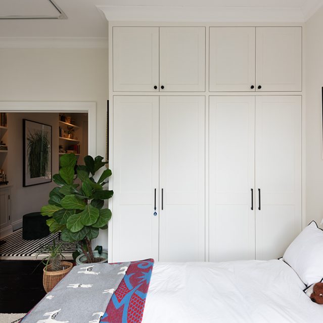 A white wardrobe with 4 doors and cupboard space at the top.