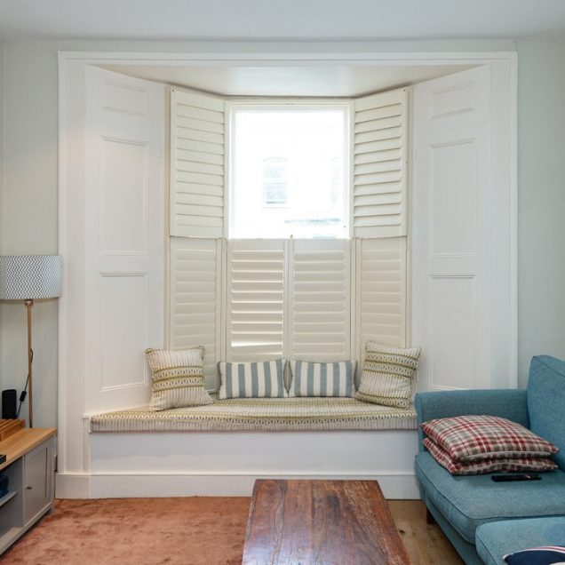 Built In bay window seat in living room with cushions on top.