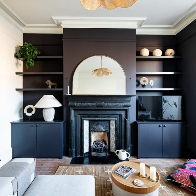 Beautiful blue built-in alcove cupboards with alcove floating shelves next to fireplace.